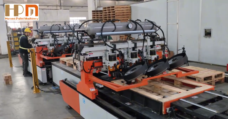 Automated industrial machine assembling wooden pallets in a factory setting.