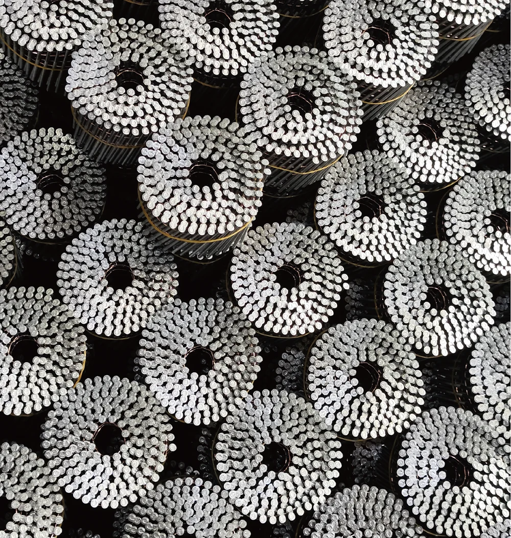 Top-down view of multiple coils of silver roofing nails.
