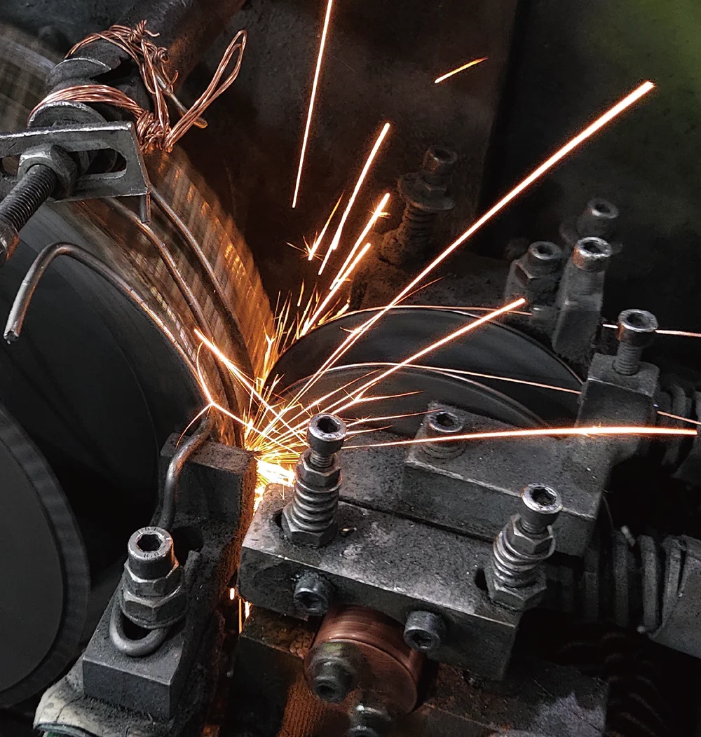 Sparks flying from an industrial machine during a metalworking process.