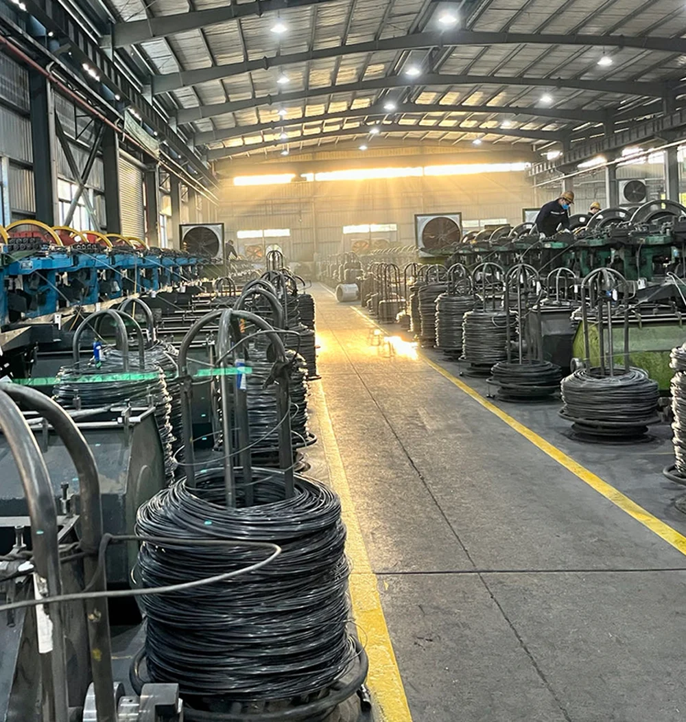 Industrial factory floor with coils of wire and machinery.